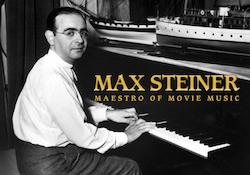 Max Steiner poses while sitting at his upright piano