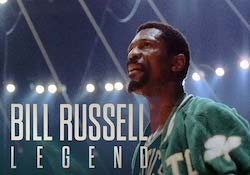 Bill Russell stands under stadium lights in Boston Celtics uniform