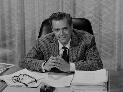 Desi Arnaz sitting at a desk