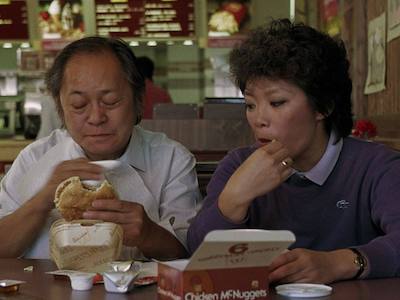 A man and a woman eating at a fast food restaurant.