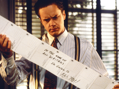 Tim Robbins reading a long sheet of paper.