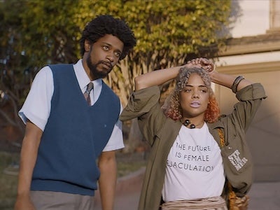 Actors LaKeith Stanfield and Tessa Thompson standing in front of a house. 