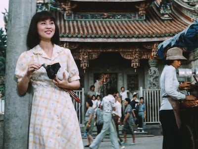A woman smiling in front of a temple.