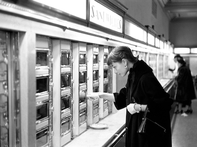 Audrey Hepburn retrieving food from an Automat.