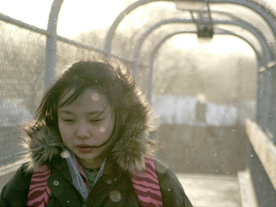 A girl wearing a backpack in the snow.
