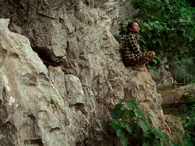 A person sitting on a mountainside.