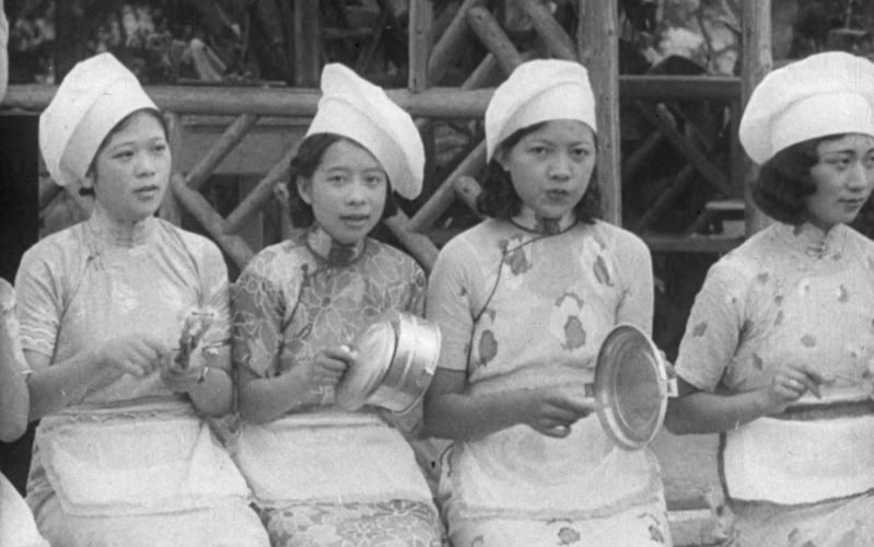 Young Chinese women wearing cook's hats.