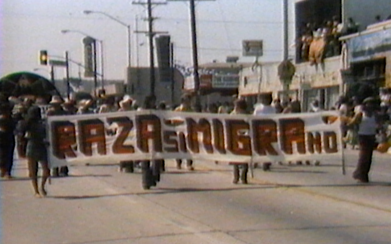 Demonstrators in the street holding a sign that reads 