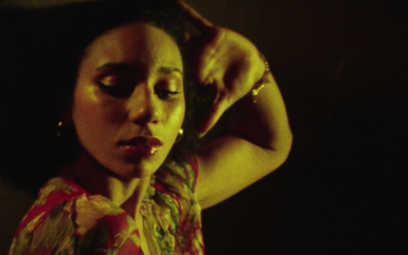 A woman dancing with her hand on her head.