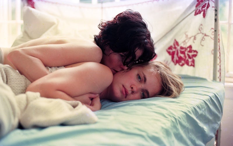 Two women embracing in bed.