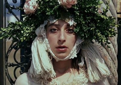 A woman wearing a garland of leaves and flowers on her head.