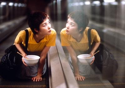 A woman looking through a window while holding a bowl.