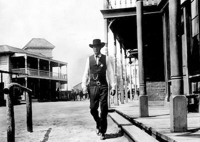 Actor Gary Cooper dressed as a sheriff in a Western town.