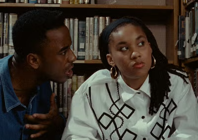 A woman looking away from a man who is talking to her in a library.