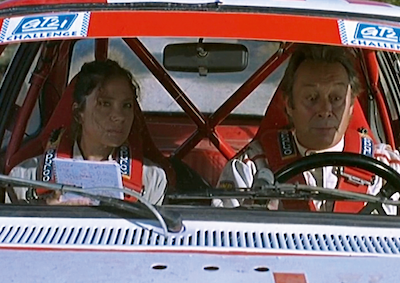 A woman and man sitting in the front of a car.