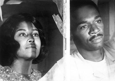 Abbey Lincoln and Ivan Dixon looking through a window.