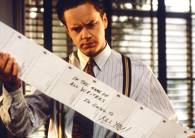 Tim Robbins reading a long sheet of paper.
