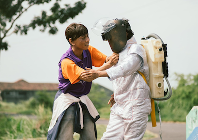 A man grabbing another person in a faux space suit.