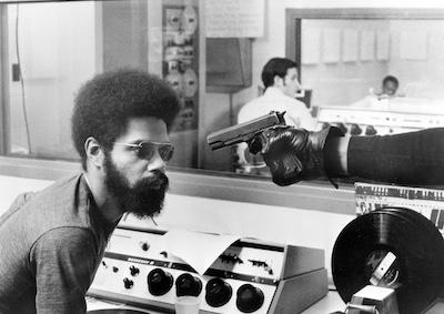 A man looking at a gun that is pointed to his face.