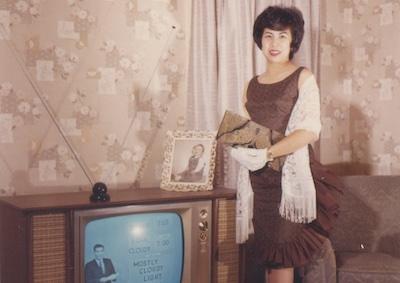 A woman standing next to a TV set.