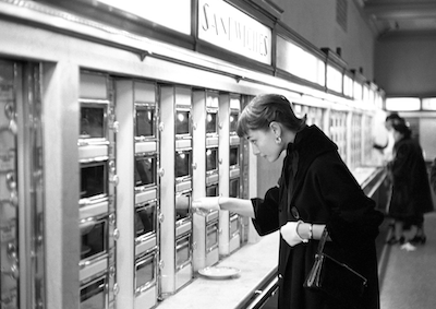 Audrey Hepburn retrieving food from an Automat.