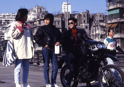 Devoted to You Three people talking in a city street.