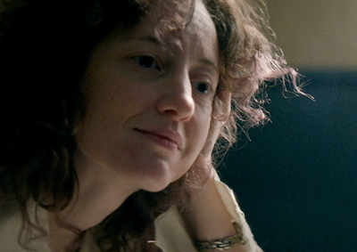 A woman resting her head on her hand.