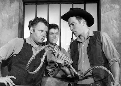 Three men in old Western attire looking at a noose.