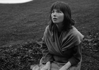 Bjork kneeling in grass.
