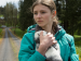 A girl hugging a rabbit outdoors.