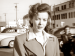 Candid photo of Ida Lupino standing by a parking lot.