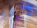 A young girl looking at the camera, surrounded by swirls of light.