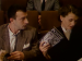 A man and woman sitting in a movie theater, holding film magazines.