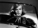Anne Francis driving and holding a phone.