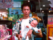 A man holding a plastic baby in a store.
