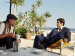 Elliott Gould sitting in a beach chair.