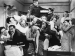 13 people piled on top of each other in a small room.