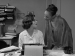 Two women gazing closely at each other in an office.