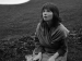 Bjork kneeling in grass.